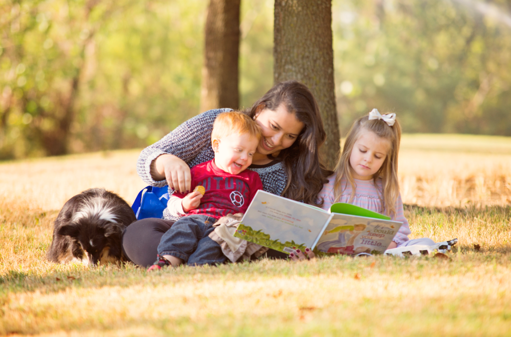 An au pair from Au Pair in America helping children with their homework and reading.