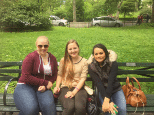 Three au pairs resting on a park bench in Central Park