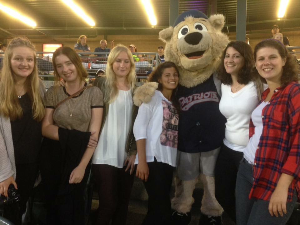 Au pairs pose for a picture with Slider, the team's mascot