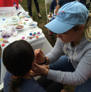 Au pairs provide face painting to kids at the Kinhaven 5k and Fun Run