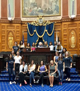 Representative Cory Atkins with au pairs from Au Pair in America in the Massachusetts House Chamber
