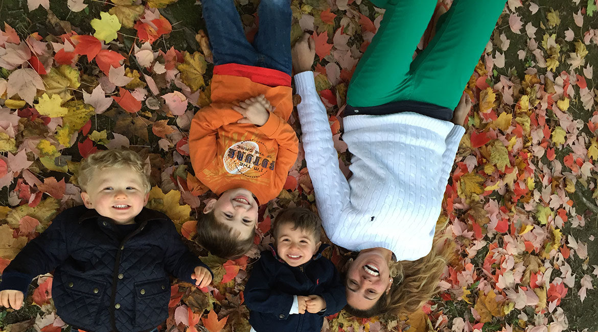 Au Pair with children in autumn leaves