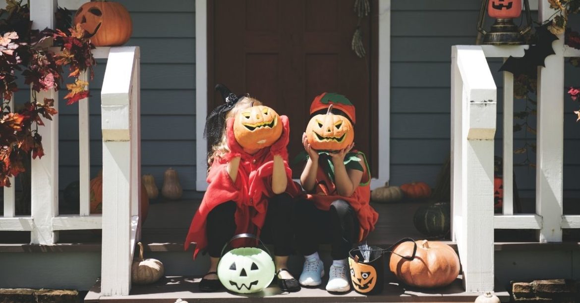 Children on porch with pumpkins for Halloween | Au Pair in America