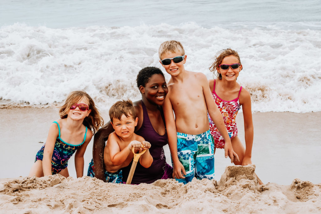 au pair with host children at the beach