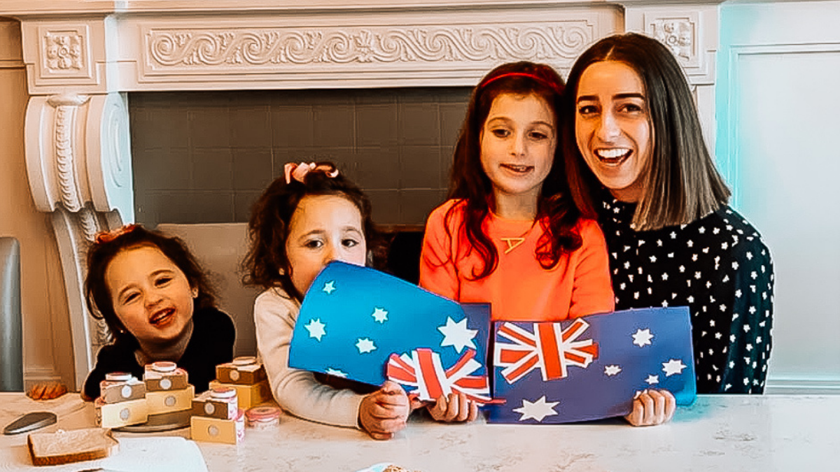 Au pair from Australia with three host children holding Australian flags