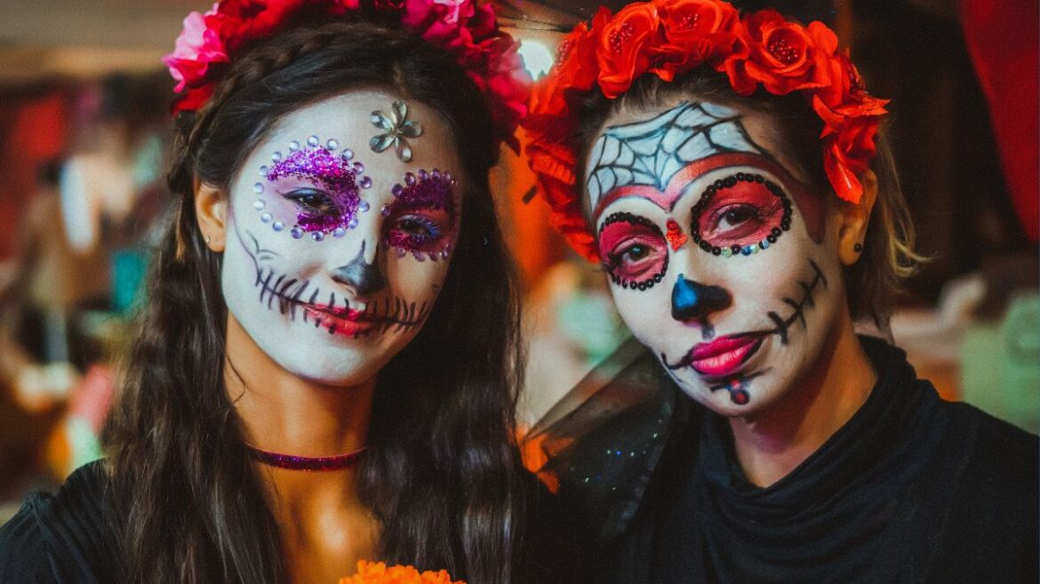 Two women with faces painted for Día de los Muertos