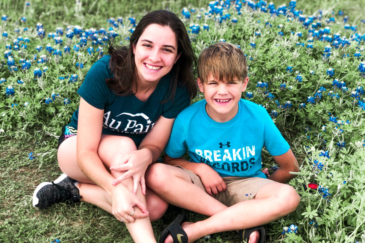 Au pair and host child in the spring during spring flowers