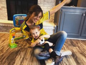 Au pair and host child in soccer jerseys