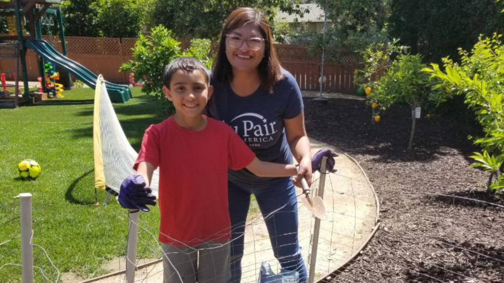 Au pair and host child gardening