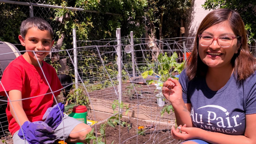 Au pair and host child gardening