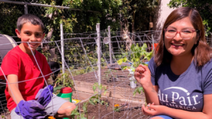 Au pair and host child gardening