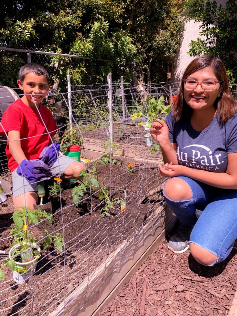 Au pair and host child gardening