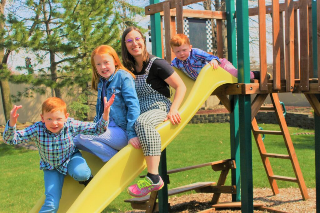 Au pair and host children on slide