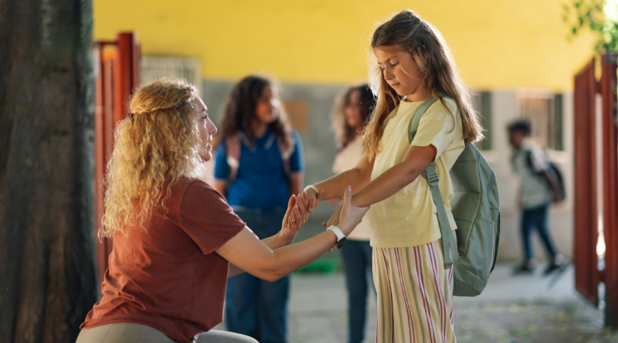 mother encouraging daughter on the first day back to school